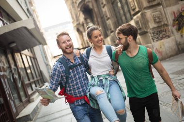 Harita gezi şehirde tutan genç mutlu turist