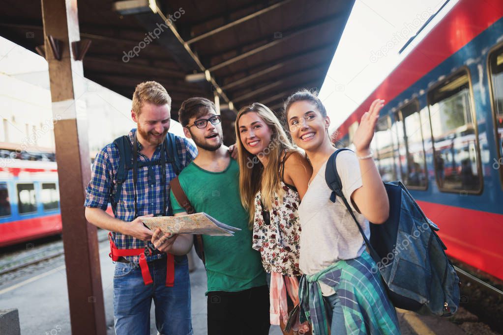 Young group of travelling tourists at train station