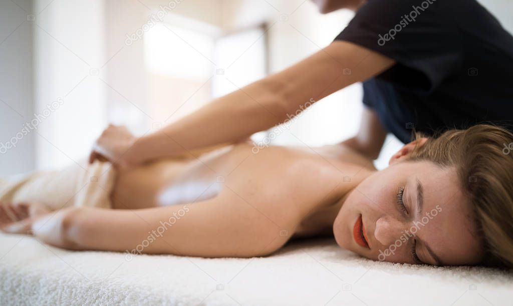 Thai massage therapist treating patient at healthcare salon