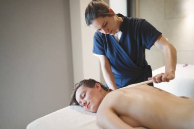 Masör masaj bambu sopalarla tedavi sırasında kullanarak