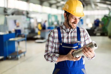 Fabrikada çalışan bir gülümseyen metal mühendisi portresi