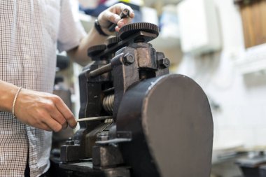 Metal daha ince hale getirmek için makine kullanarak Goldsmith