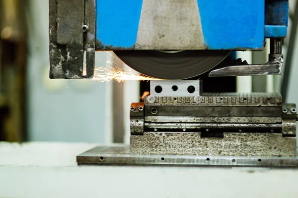 Polishing surface of metal in factory with sparkles showing during process