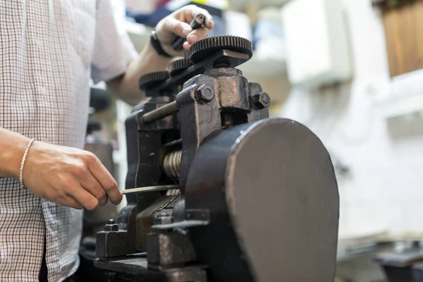 Metal daha ince hale getirmek için makine kullanarak Goldsmith