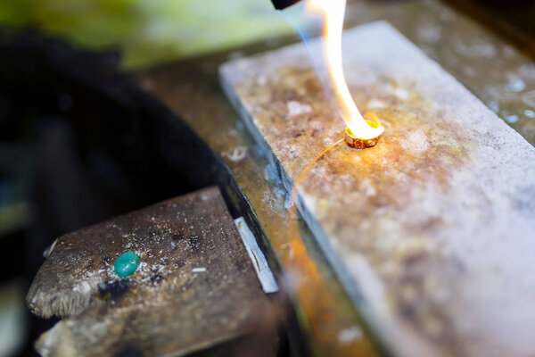Goldsmith working on a ring with torch