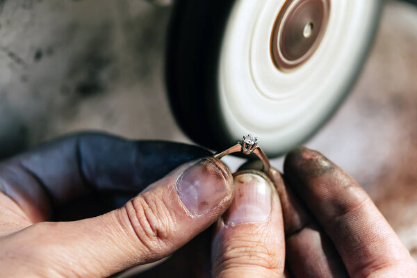 Jeweler polishing jewelry with tools