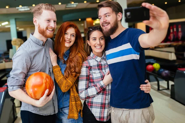 Mutlu arkadaşlar eğlenmeye ve birlikte Bovling oynarken zevk