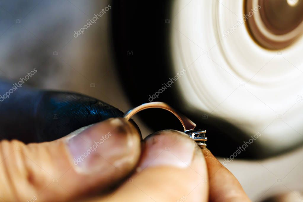Jewelery polishing ring in workshop with adequate tools