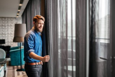 Yakışıklı adam lüks otel odasındaki manzarayı