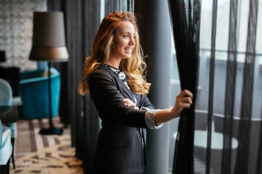 Muhteşem sarışın pencereden bakıyor ve gelecek hakkında düşünme