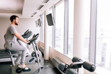 Sportif erkek spor salonunda bisiklet üzerinde egzersiz