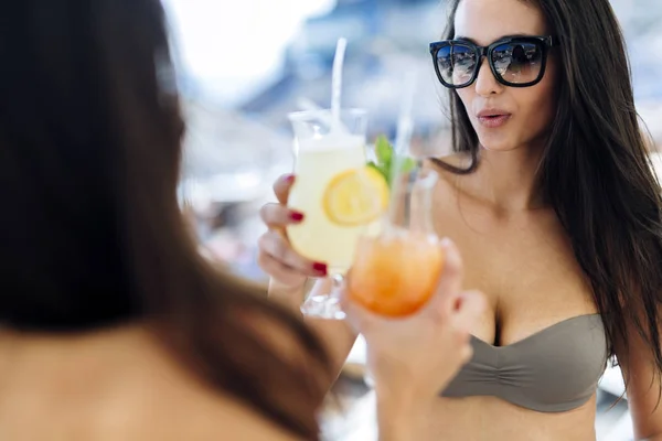 Женщины на пляже наслаждаются коктейлями — стоковое фото