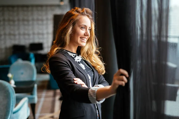 Muhteşem sarışın pencereden bakıyor ve gelecek hakkında düşünme