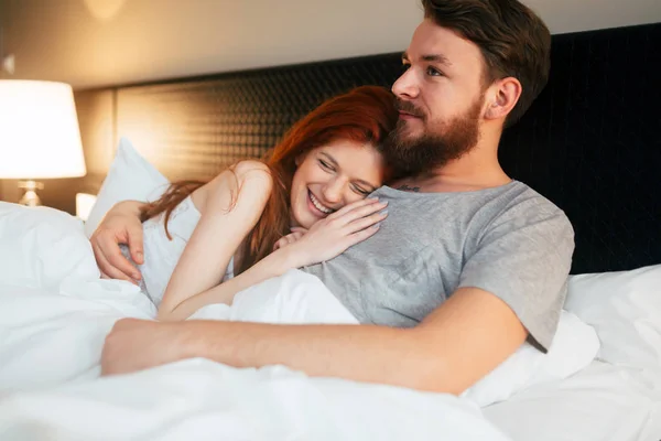 Happy couple in bed showing emotions and love