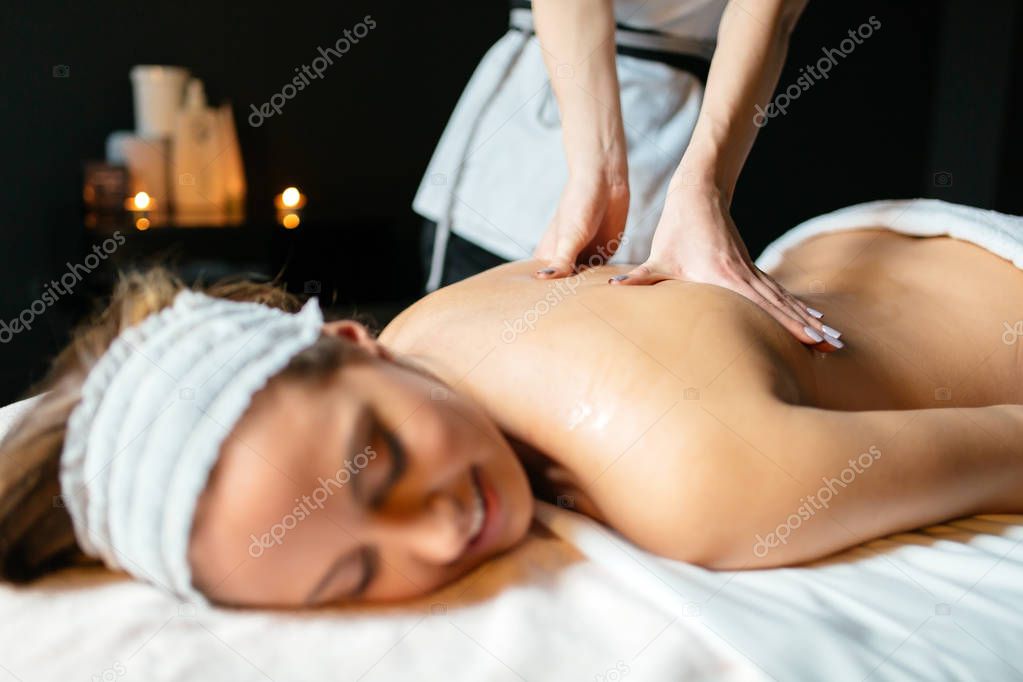Massage therapist massaging beautiful cute brown brunette