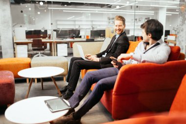 Kanepede dinlenirken aygıtlarda çalışan başarılı iş adamları