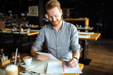 Notlar alarak ve öğle arasında kafede yeni fikirler aşağı işadamı