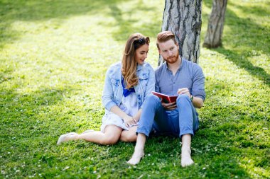 Güzel üniversite öğrencileri parkta çalışıyor.