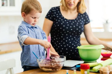 Güzel çocuk ve anne sevgi ile mutfakta pişirme