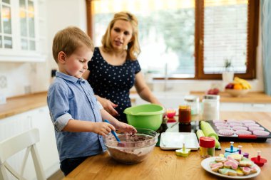 Akıllı şirin çocuk anne mutfakta kurabiye hazırlama yardım