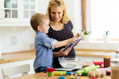 Akıllı şirin çocuk anne mutfakta kurabiye hazırlama yardım