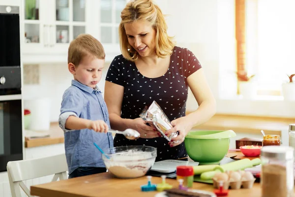 Beautiful child and mother baking in kitchen with love