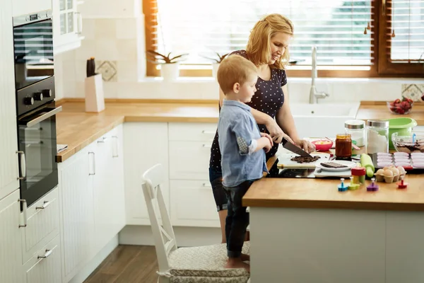 Güzel çocuk ve anne sevgi ile mutfakta pişirme