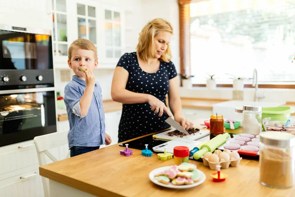 Mutlu anne ve çocuk mutfakta kurabiye hazırlıyor.