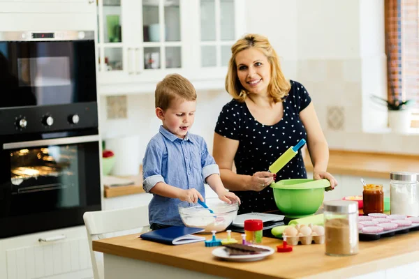 Beautiful child and mother baking in kitchen with love