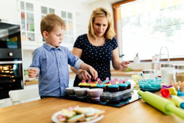 Akıllı şirin çocuk anne mutfakta kurabiye hazırlama yardım