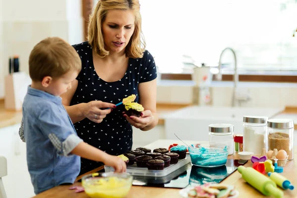 帮助准备松饼在厨房的妈妈的孩子 — 图库照片