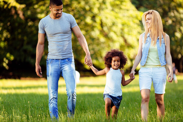 Счастливая молодая пара проводит время со своей дочерью на природе
