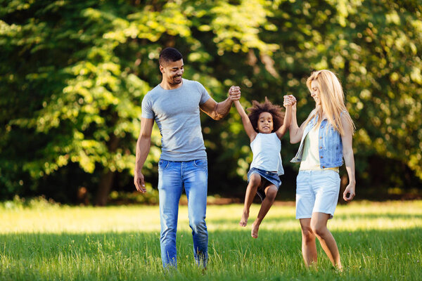 Счастливая молодая пара проводит время со своей дочерью на природе
