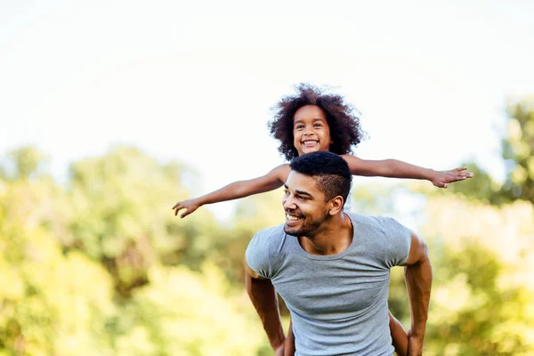 Retrato Del Joven Padre Cargando Hija Sobre Espalda Naturaleza —  Fotos de Stock