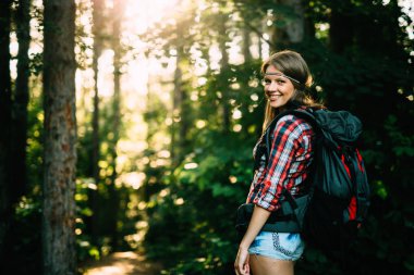 Kadın backpacker orman zammı advanture üzerinde yola çıktı