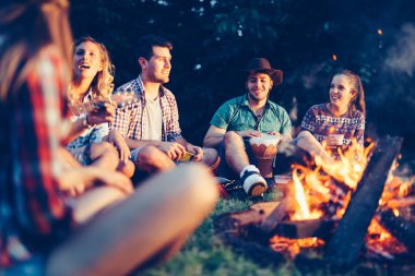 Arkadaşlar gece kamp ateşi yakın müzik keyfi