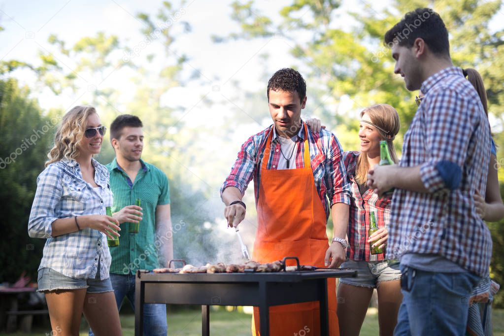 Young people having  bbq party in nature