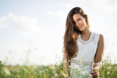 Genç, güzel, mutlu bir kadın doğada vakit geçiriyor.