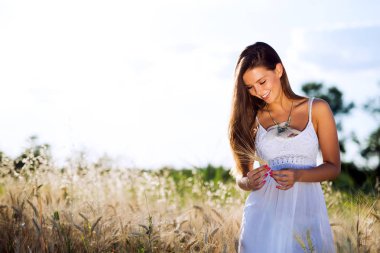 Genç, güzel, mutlu bir kadın doğada vakit geçiriyor.