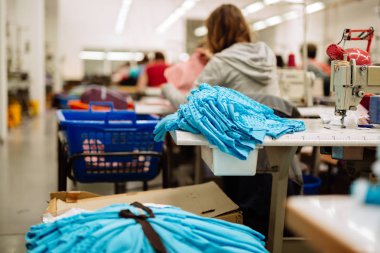 Dikiş makineleri oturan tekstil sektöründe çalışan işçi
