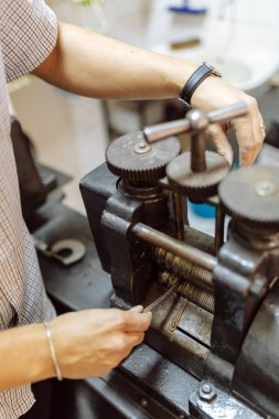 Metal daha ince hale getirmek için makine kullanarak Goldsmith