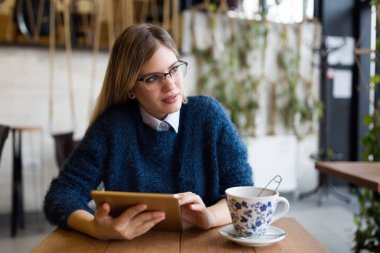 Dijital tablet kullanan genç çekici kadın portresi