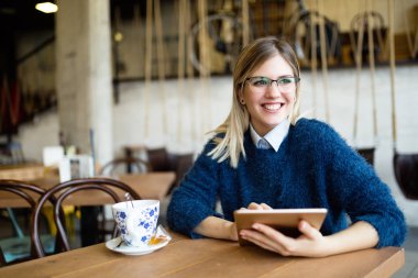 Dijital tablet kullanan genç çekici kadın portresi