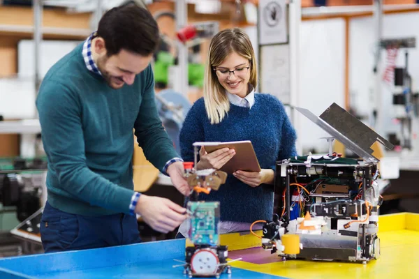 Young students of robotics working on project together