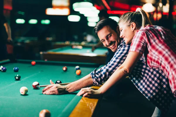 年轻迷人的情侣一起玩台球在酒吧 — 图库照片
