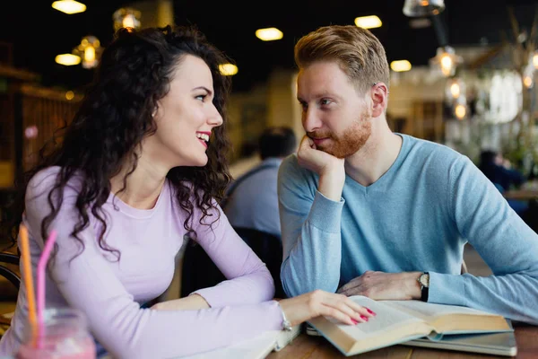 Genç çekici öğrenciler kafeteryada kitap okuyarak zaman geçiriyorlar.