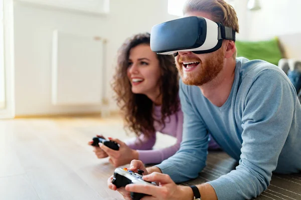 幸せな若いカップル仮想現実ヘッドセット自宅はビデオゲームをプレイ — ストック写真