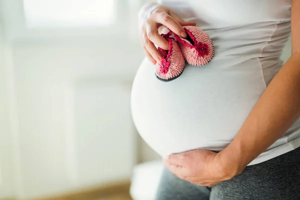 Pregnant Woman Holding Baby Girl Shoes Her Belly — Stock Photo, Image