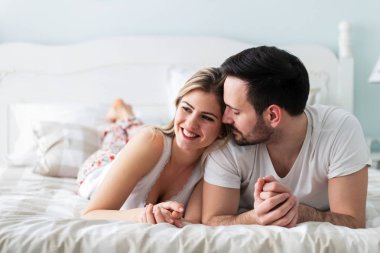 Genç mutlu çift yatak odasında romantik vakit geçiriyor