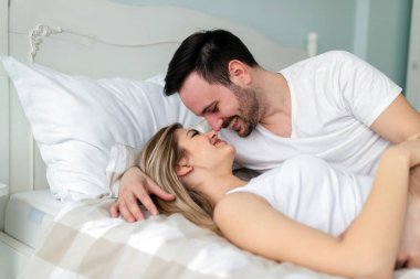 Genç mutlu çift yatak odasında romantik vakit geçiriyor